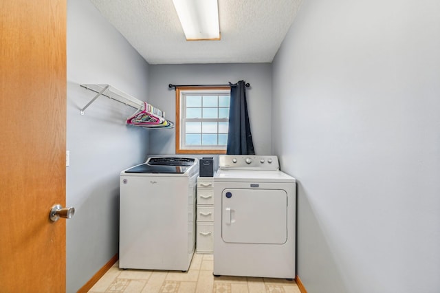 clothes washing area with a textured ceiling and separate washer and dryer