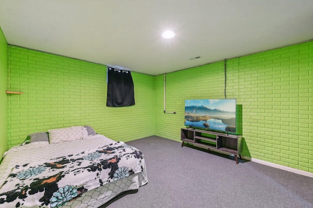 carpeted bedroom with brick wall