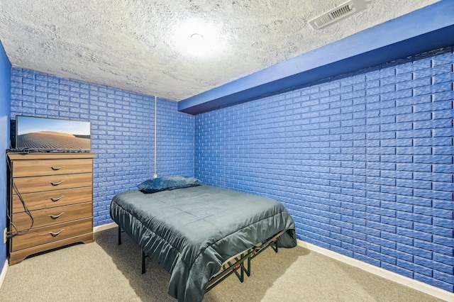 bedroom featuring carpet flooring, a textured ceiling, and brick wall