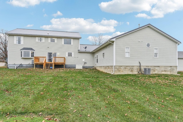 rear view of house with a deck, a yard, and central air condition unit