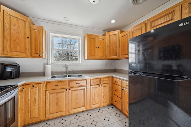 kitchen featuring black refrigerator, electric range, and sink