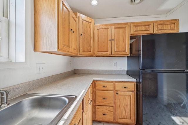 kitchen featuring black fridge and sink