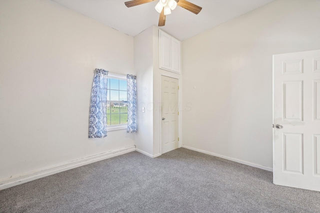 carpeted spare room with vaulted ceiling and ceiling fan