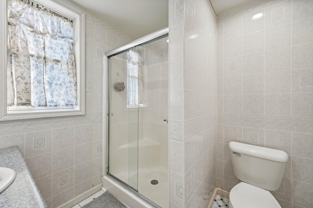 bathroom with toilet, vanity, tile walls, and walk in shower