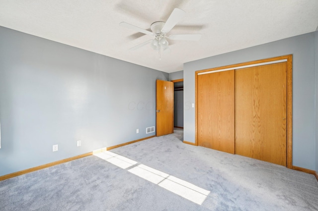 unfurnished bedroom with ceiling fan, a closet, and light colored carpet