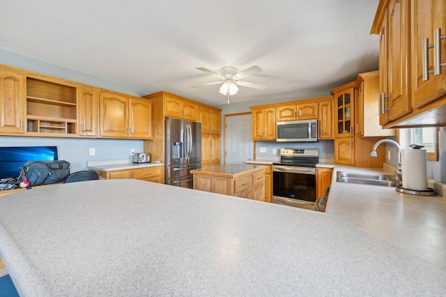 kitchen with kitchen peninsula, stainless steel appliances, ceiling fan, and sink