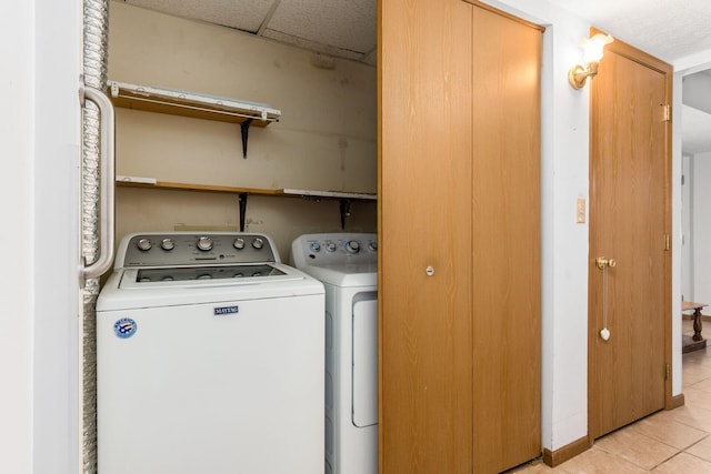 laundry area with separate washer and dryer and light tile patterned flooring