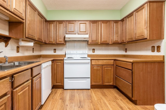 kitchen with a textured ceiling, light hardwood / wood-style flooring, white appliances, and sink