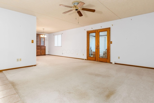 empty room featuring a textured ceiling, ceiling fan with notable chandelier, light carpet, and french doors