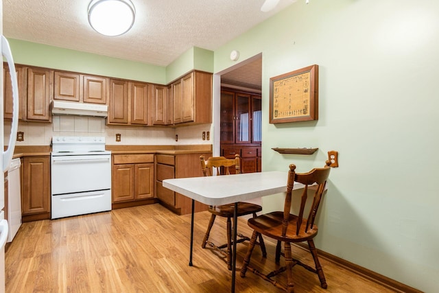 kitchen with electric stove, decorative backsplash, light hardwood / wood-style floors, and a textured ceiling