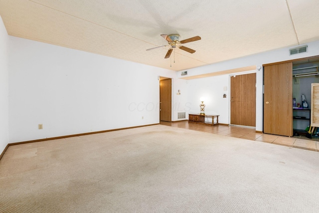 carpeted spare room with a textured ceiling and ceiling fan