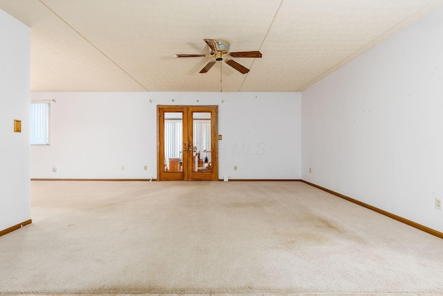 carpeted spare room with french doors, a textured ceiling, and ceiling fan