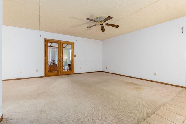 empty room with ceiling fan, french doors, carpet, and a textured ceiling