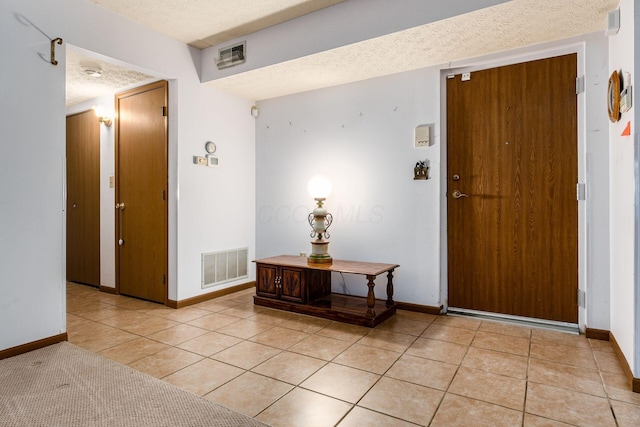 tiled foyer with a textured ceiling