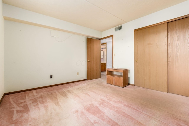 unfurnished bedroom featuring a closet and light colored carpet