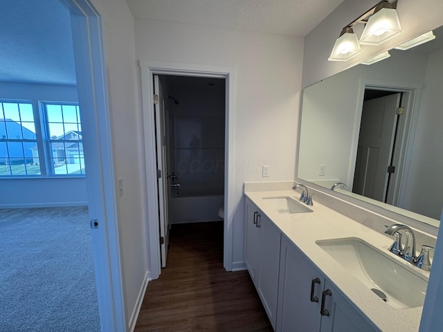 full bathroom with a textured ceiling, vanity, bathing tub / shower combination, and toilet