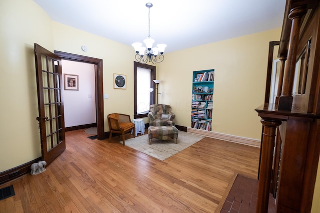 living area featuring hardwood / wood-style floors and a chandelier