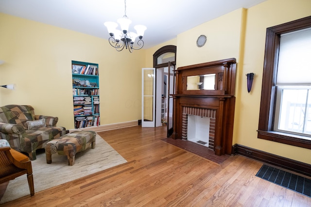 living area with hardwood / wood-style floors and an inviting chandelier