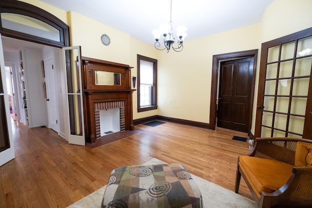 unfurnished living room with a chandelier, hardwood / wood-style flooring, and a fireplace