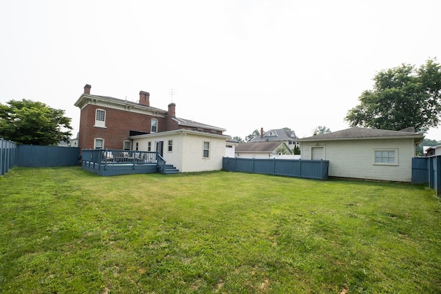 back of property with a lawn and a deck