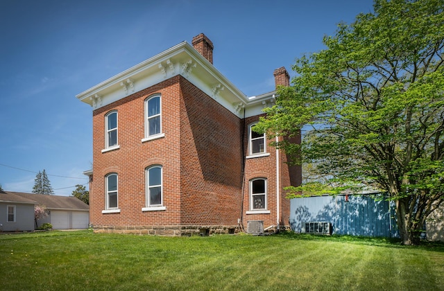 rear view of house with a yard and cooling unit