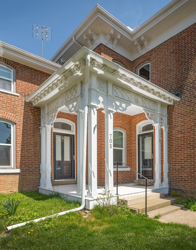 view of exterior entry featuring a yard