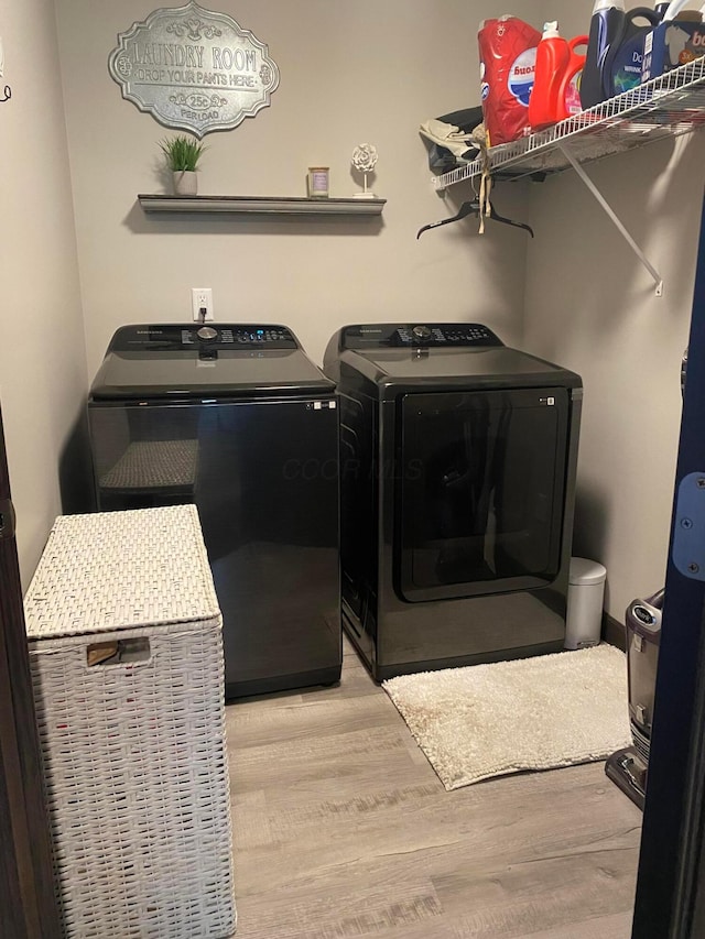 laundry room with washer and dryer and light hardwood / wood-style floors