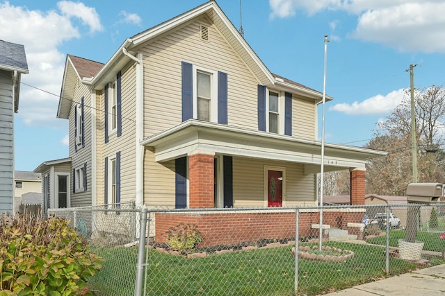 front of property with covered porch and a front yard