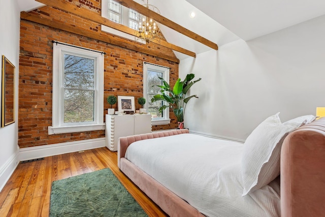 1030 Jaeger St, Columbus, OH 43206 - bedroom with a chandelier, hardwood / wood-style floors, high vaulted ceiling, brick wall, and beamed ceiling