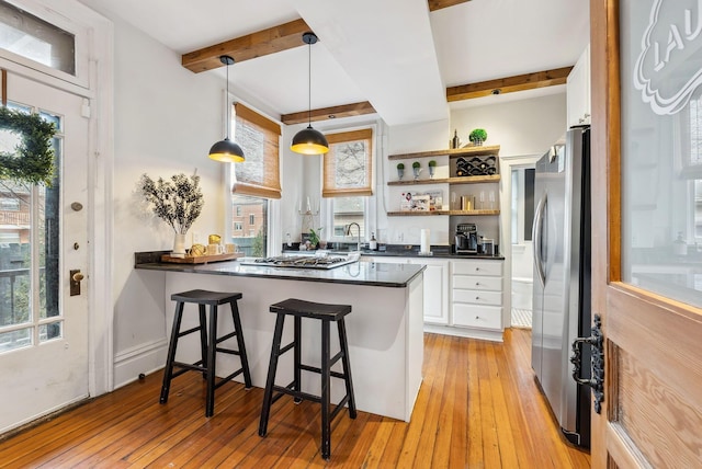 1030 Jaeger St, Columbus, OH 43206 - kitchen featuring appliances with stainless steel finishes, dark countertops, white cabinetry, beam ceiling, and a peninsula