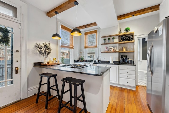 1030 Jaeger St, Columbus, OH 43206 - kitchen with stainless steel appliances, light wood-type flooring, beam ceiling, white cabinets, and a peninsula