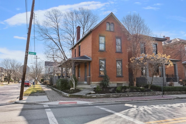 exterior space with brick siding and a chimney