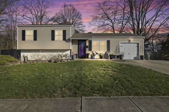 tri-level home featuring a lawn and a garage