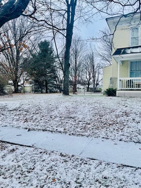 yard layered in snow with a porch