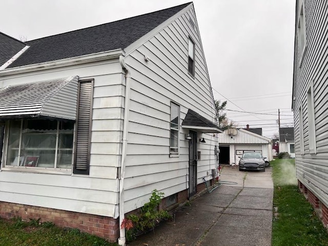 view of side of home featuring an outbuilding and a garage