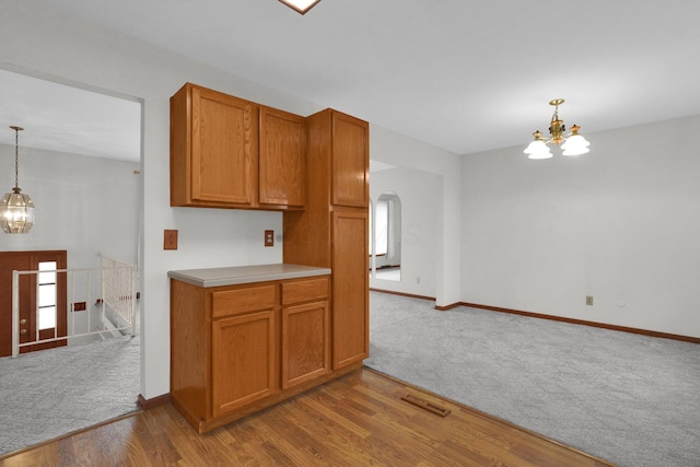 kitchen featuring decorative light fixtures, an inviting chandelier, and light hardwood / wood-style flooring