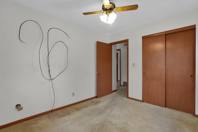 unfurnished bedroom featuring ceiling fan, light carpet, and a closet