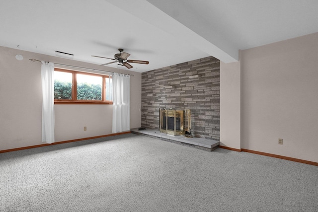 unfurnished living room featuring carpet flooring, ceiling fan, a large fireplace, and beam ceiling