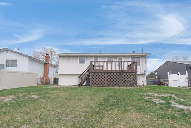 rear view of house featuring a wooden deck and a yard