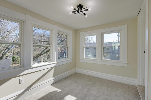 unfurnished sunroom with a wealth of natural light and a chandelier