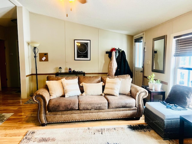 living room featuring hardwood / wood-style flooring, ceiling fan, and vaulted ceiling