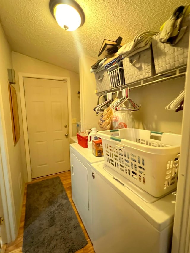 laundry room with a textured ceiling, dark hardwood / wood-style floors, and separate washer and dryer