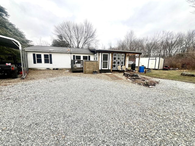 view of front of house featuring a carport and a shed