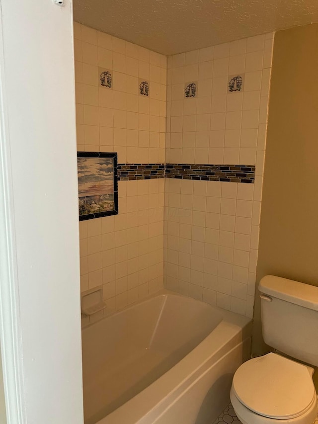 full bathroom with a textured ceiling and toilet