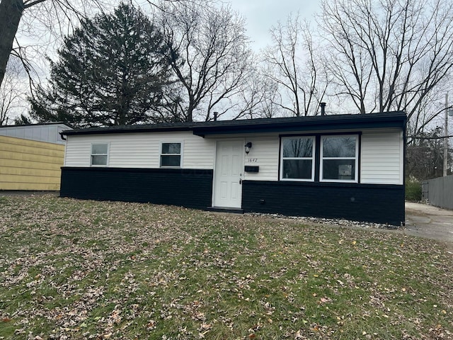 view of front of house featuring brick siding, a front yard, and fence