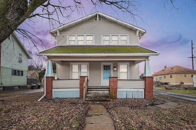 bungalow-style home featuring a porch and central AC unit