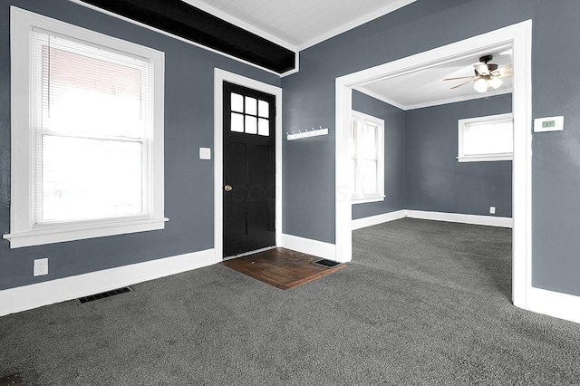 carpeted foyer featuring crown molding and ceiling fan