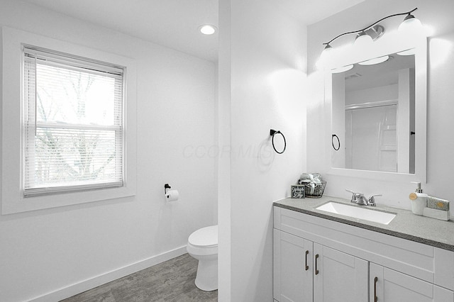 bathroom featuring vanity, toilet, hardwood / wood-style floors, and walk in shower