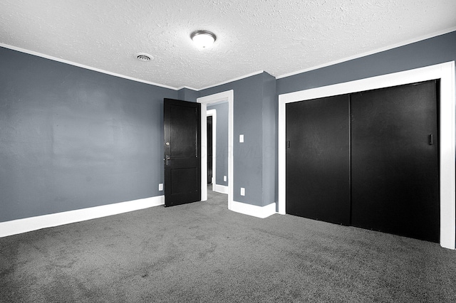 unfurnished bedroom with ornamental molding, carpet flooring, a textured ceiling, and a closet