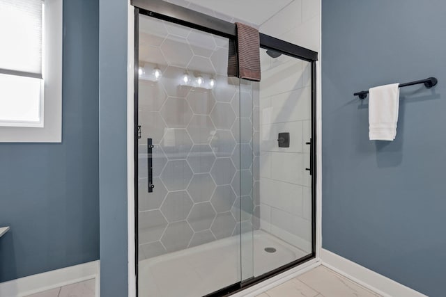 bathroom featuring a shower with door and a healthy amount of sunlight